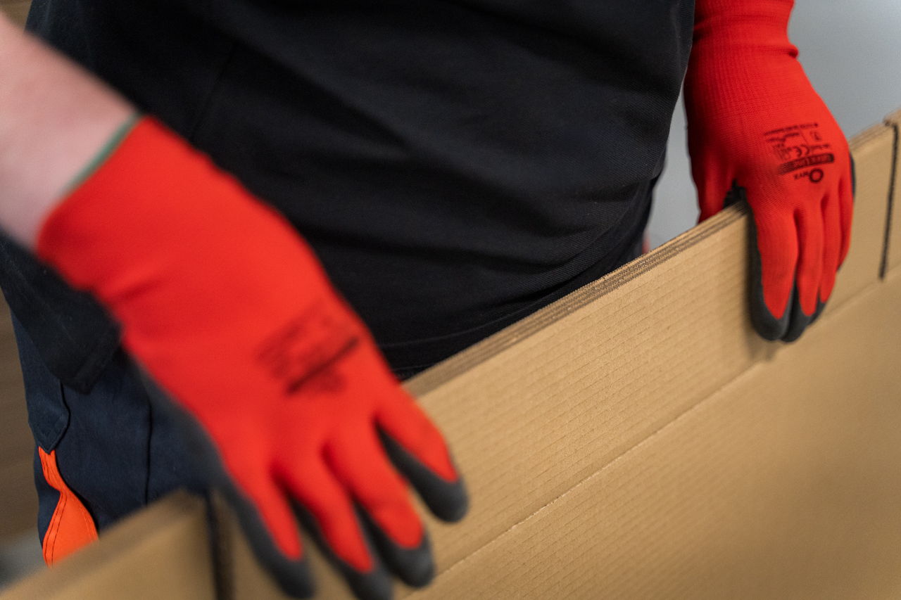 Pallety z tekturą falistą w hali magazynowej.